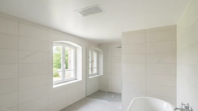 Bouche d'extraction de VMC au plafond d'une salle de bain rénovée